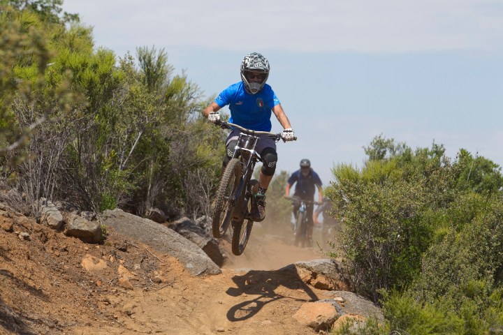 a man riding a bike down a dirt road