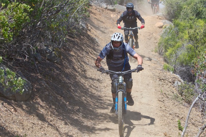 a man riding a bike down a dirt road