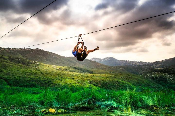 a person flying through the air on a grassy hill